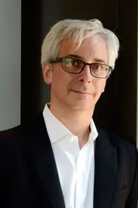 Art Markman, a white man with white hair and glasses, wearing an open-collared shirt and blazer.